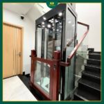 Thang máy IWa Luxury lắp cạnh cầu thang trong nhà, thiết kế kính gọn, phù hợp nhà phố