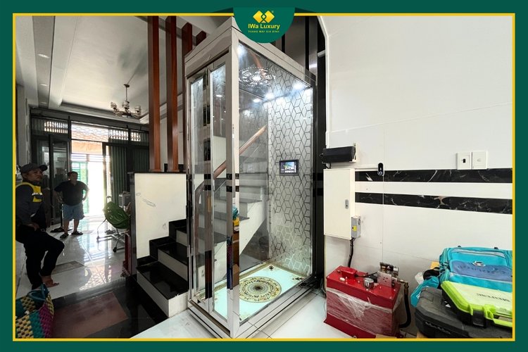 Thang máy gia đình bốn tầng tại Bình Tân cabin kính cạnh cầu thang