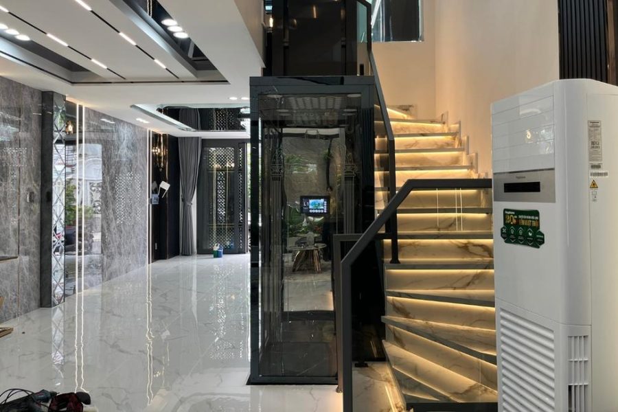 Thang máy mini cabin kính màu đen cạnh cầu thang
